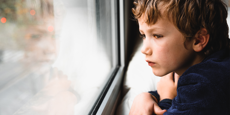 unhappy-boy-staring-out-of-a-window