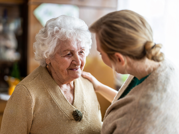 image of a elder woman with a carer or relative comforting and reassuring her